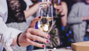 יד מחזיקה כוס שמפניה במסיבה, אלכוהול וגאוט